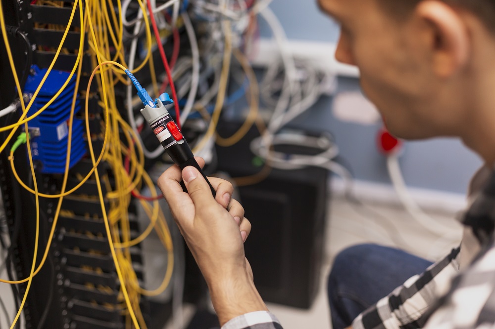 Engenheiro verificando se há rompimento de fibra óptica.